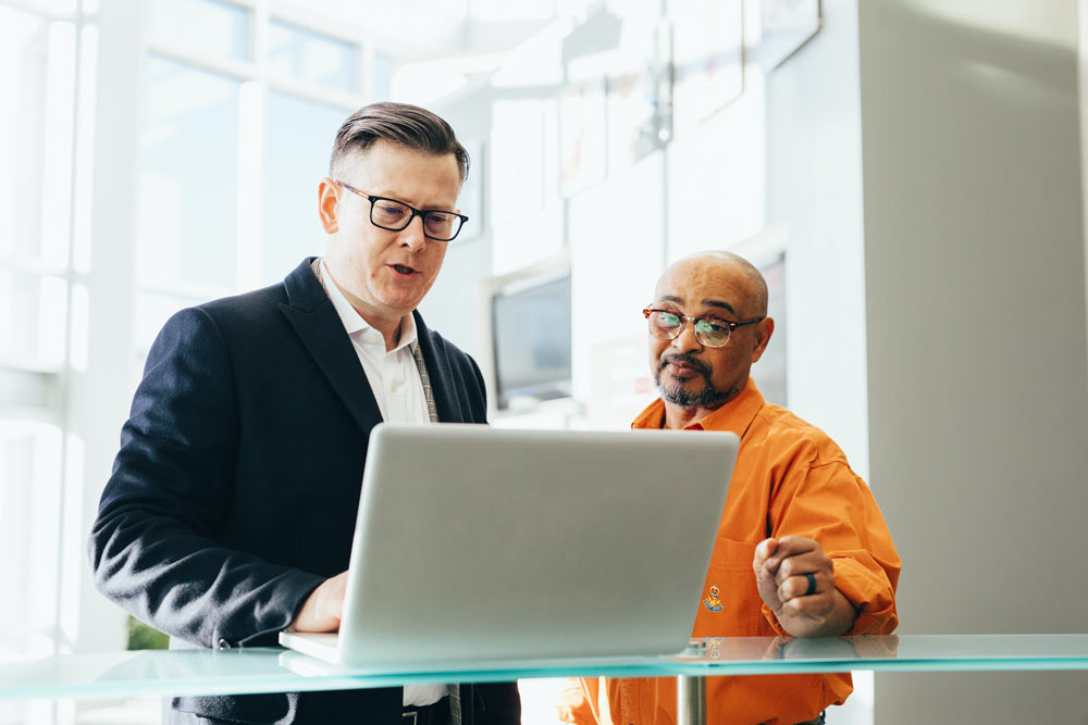 Zwei Personen stehen vor Computer